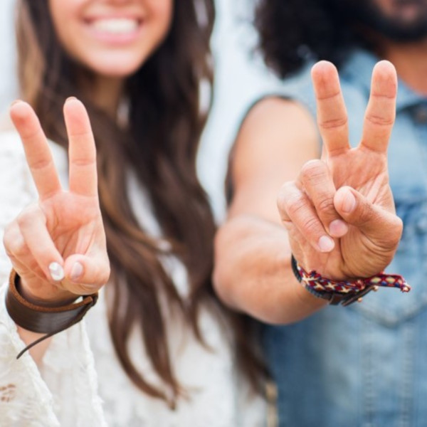 Three young people holding up the peace sign.